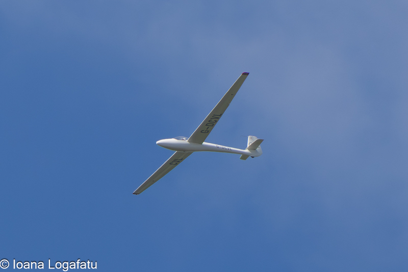 Flying glider against a bright blue sky